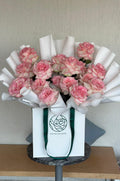 Bouquet of pink flowers in a white box with 'Petalscape logo on a wooden surface.